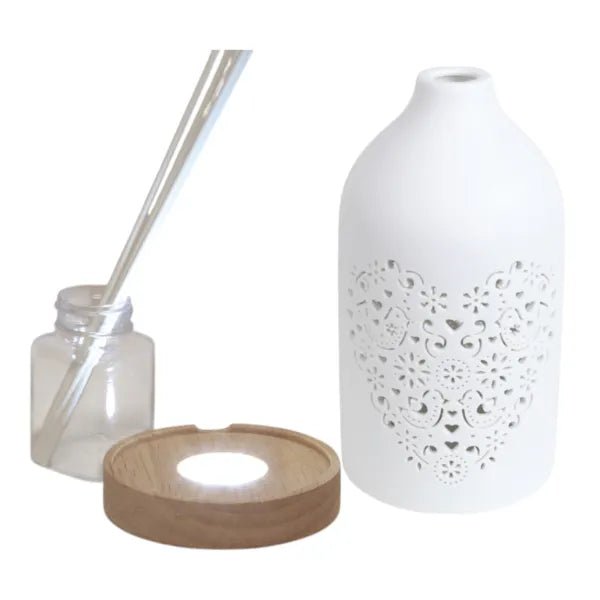 Heart design reed diffuser shown disassembled with LED base, bottle, and reeds

