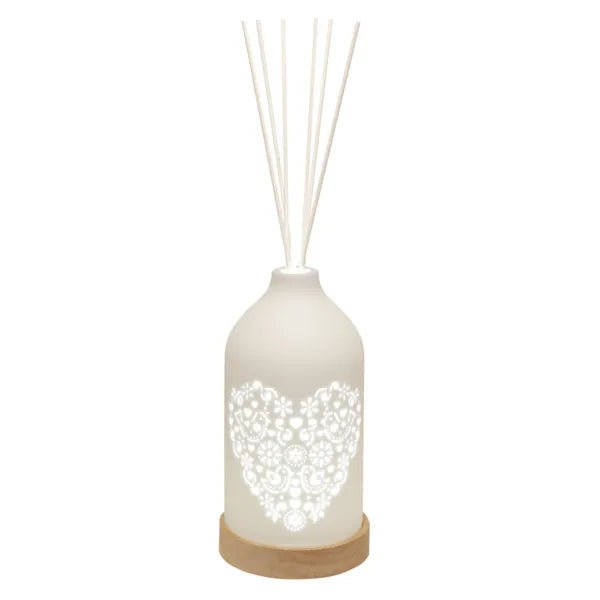 LED ceramic reed diffuser with glowing heart cut-out and white reed sticks

