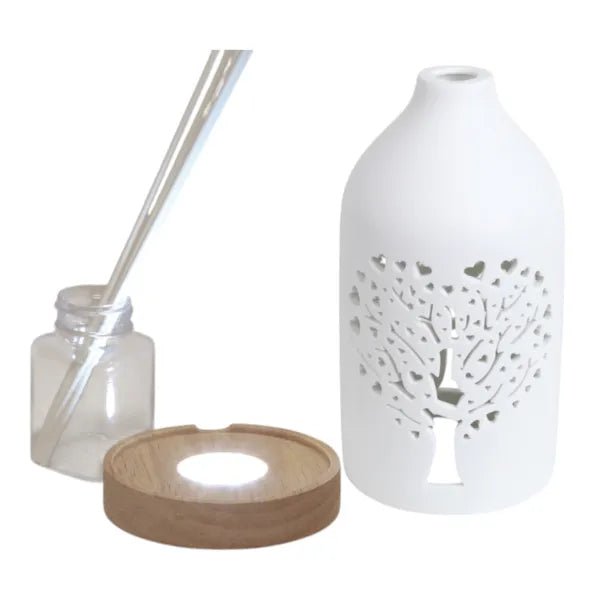 Disassembled reed diffuser set showing bottle, LED base, ceramic cover, and reeds

