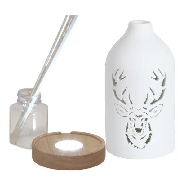 Reed diffuser set components showing the ceramic stag cover, wooden LED base, bottle and reed sticks.