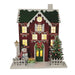 Wooden red townhouse with green roof and wreath, lit windows and snowman, 24 x 24cm, on white background.