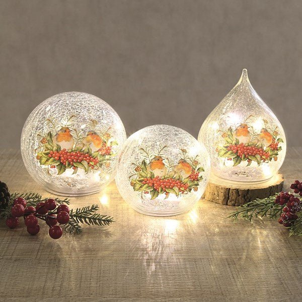 Trio of LED crackle glass robin lights glowing on a table

