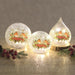 Trio of LED crackle glass robin lights glowing on a table

