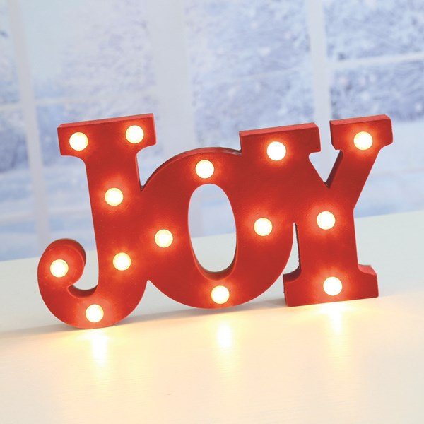 Glowing red JOY LED marquee sign styled on a festive tabletop.