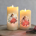 Pair of LED robin candles glowing on a wooden surface, 12.5cm and 15cm.

