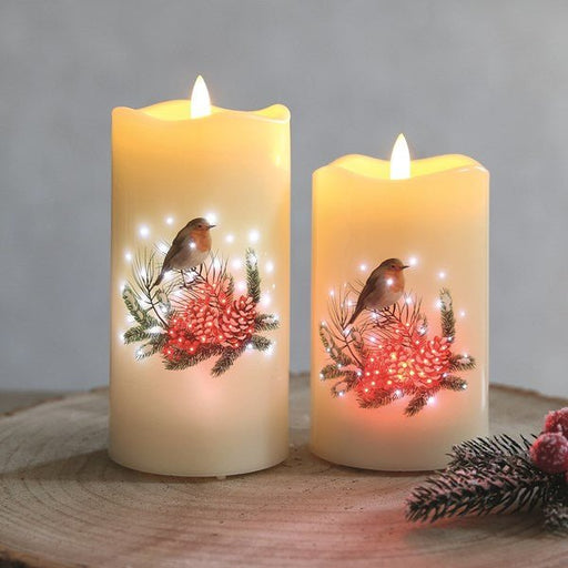 Pair of LED robin candles glowing on a wooden surface, festive décor.

