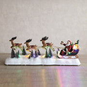 LED Santa sleigh glowing on a tabletop with snowy trees

