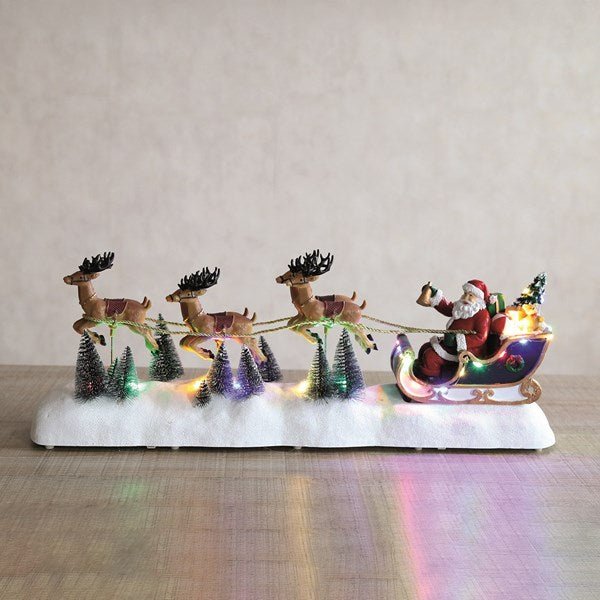 LED Santa sleigh glowing on a tabletop with snowy trees


