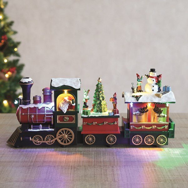 LED Santa Train glowing on a tabletop with rotating tree

