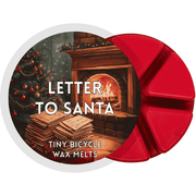 Red Letter to Santa wax melt with festive fireplace scene, stacked envelopes, and decorated Christmas tree.