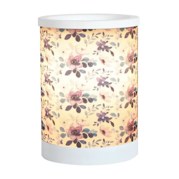 Lilac floral electric wax melt burner switched on, glowing warmly through the floral design.