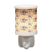 Lilac floral plug in wax melt burner switched on, glowing warmly through the floral design.