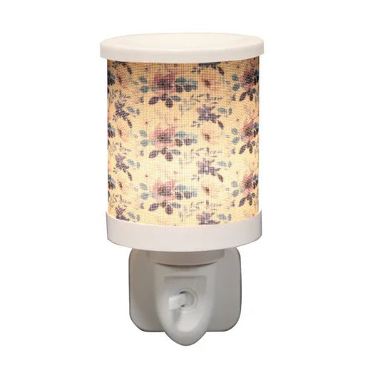 Lilac floral plug in wax melt burner switched on, glowing warmly through the floral design.