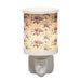 Lilac floral plug in wax melt burner switched on, glowing warmly through the floral design.