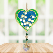 Heart-shaped Lily of the Valley Crystal Suncatcher with white bell flowers and prism heart catching sunlight in a window

