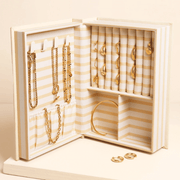 Cream linen book-style jewellery box with embroidered Little book of treasures cover design, shown standing upright.