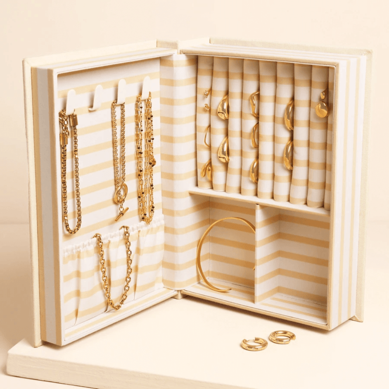 Cream linen book-style jewellery box with embroidered Little book of treasures cover design, shown standing upright.