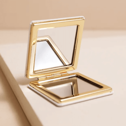 Open cat print compact mirror with gold-tone frame, showing two mirrors inside for normal and magnified reflection.