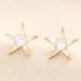 Close-up of Lisa Angel gold star stud earrings with cubic zirconia crystals