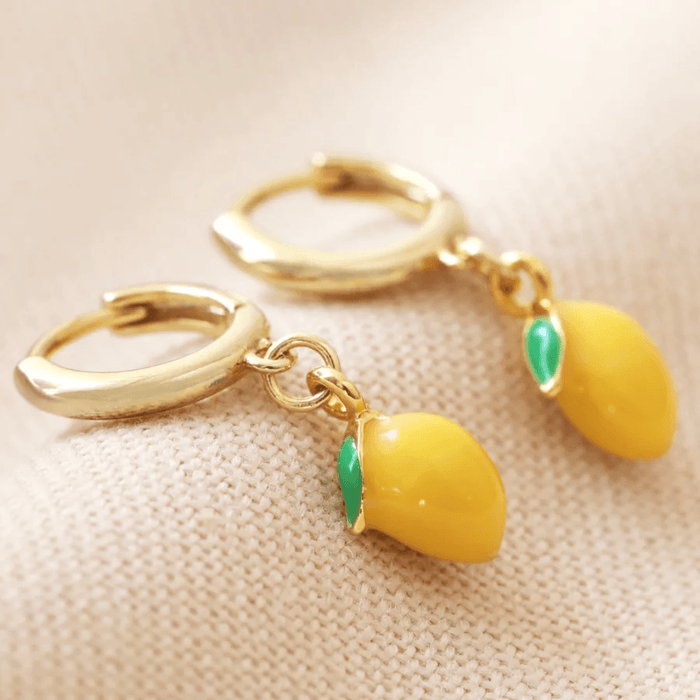 Close-up of Lisa Angel gold huggie hoop earrings with yellow enamel lemon charms