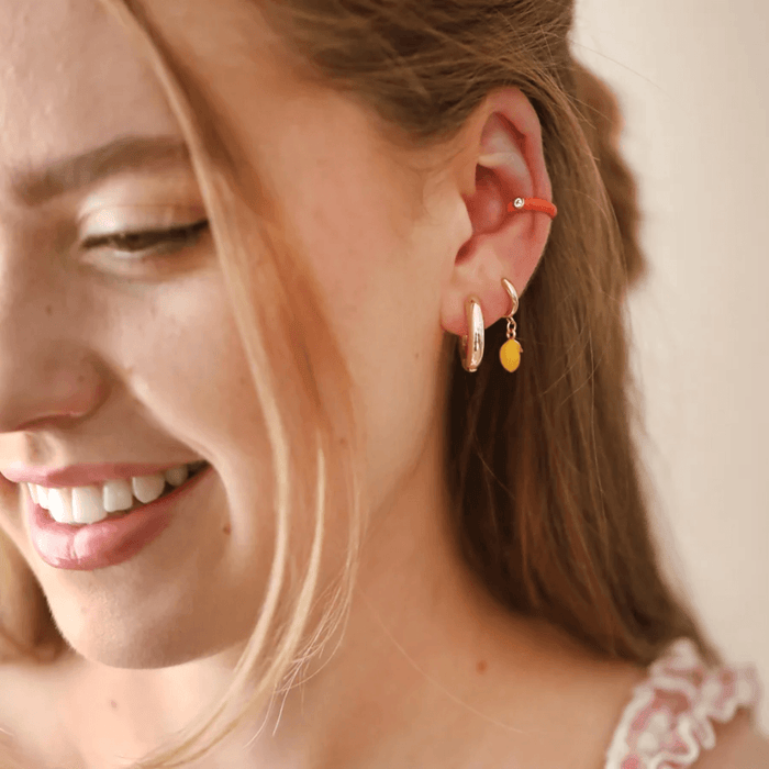 Lisa Angel Enamel Lemon gold huggie hoop earrings worn with a colourful curated ear stack