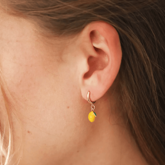 Side profile of Lisa Angel gold huggie hoop earring with dangling lemon charm