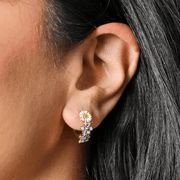 Close-up of a Lisa Angel blue enamel floral huggie hoop earring being worn