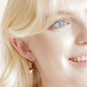 Model wearing Lisa Angel pearl and enamel toadstool huggie hoop earrings in gold