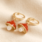 Pair of Lisa Angel gold huggie hoop earrings with red enamel toadstool charms and freshwater pearls