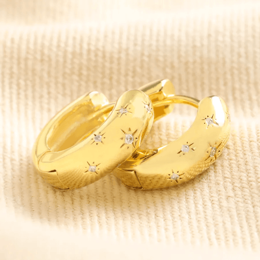 Close-up of Lisa Angel gold huggie hoop earrings with scattered crystal star details