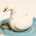 Close up of Lisa Angel swan ring holder and blue trinket dish with gold jewellery
