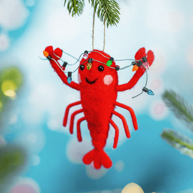 Lobster with fairy lights felt decoration hanging from a Christmas tree