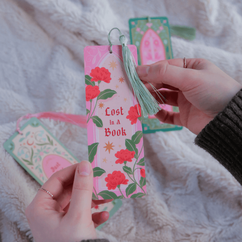 Lost In A Book floral bookmark held in hands with green tassel