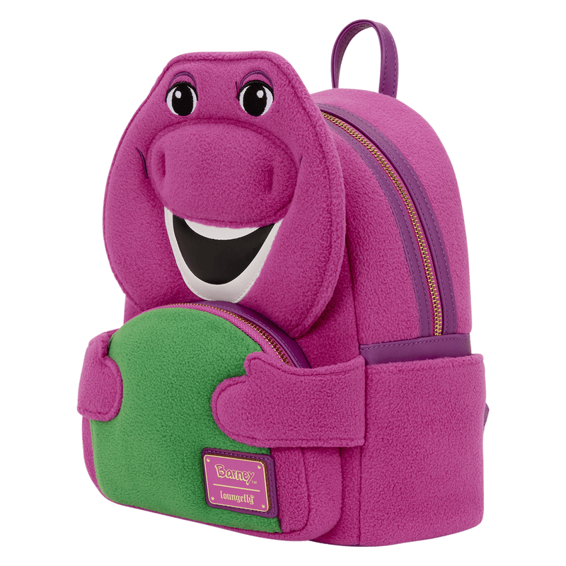 Angled view of the Loungefly Barney mini backpack showing the plush purple body, side profile, gold zip and green front pocket.