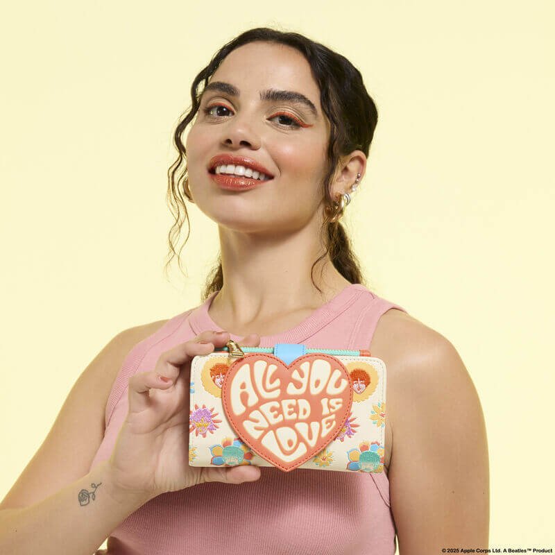 Model holding Loungefly Beatles “All You Need Is Love” wallet; heart appliqué stands out against floral print – Loungefly wallet

