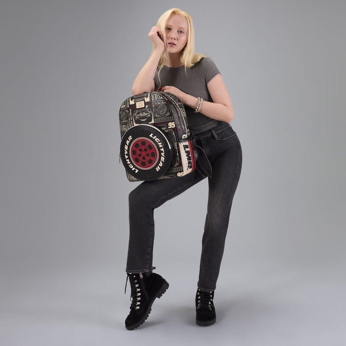 Model posing with the Loungefly Cars Lightning McQueen tyre-pocket backpack, studio grey backdrop