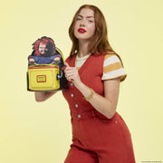 Model displaying Loungefly Chucky pop-up backpack with Chucky figure popped up, front view
