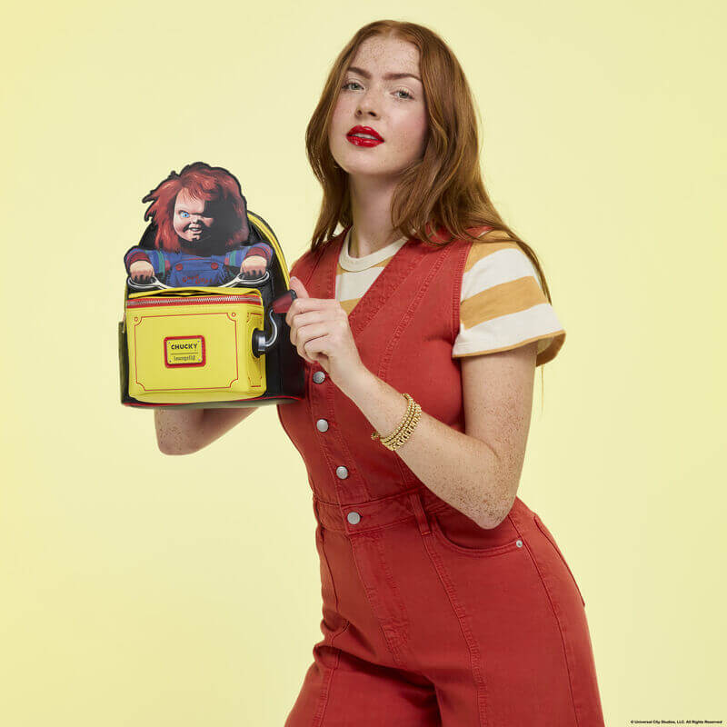 Model displaying Loungefly Chucky pop-up backpack with Chucky figure popped up, front view
