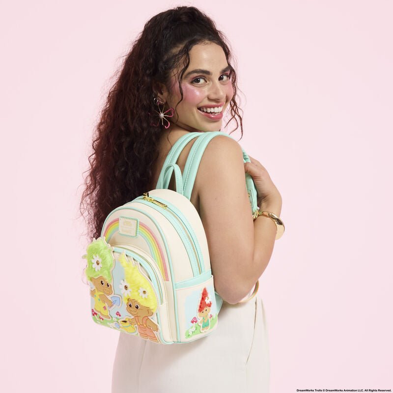 Model wearing the Loungefly Classic Trolls mini backpack with rainbow and fuzzy hair detailing