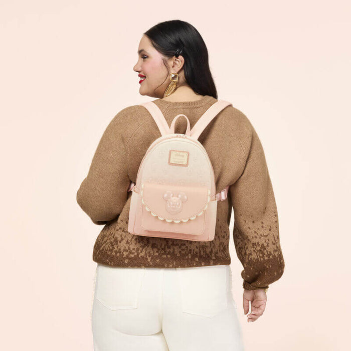 Back view of the Loungefly Disney Mickey & Friends All-Over Print Mini Backpack with pastel pink shoulder straps and embossed character pattern