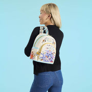 Model wearing a cream Loungefly Disney Mickey and Friends Halloween mini backpack with teal trims and trick-or-treat artwork