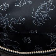 Close up of black Disney sketch lining with white outlines of Mickey, Minnie, Goofy and gloved hands