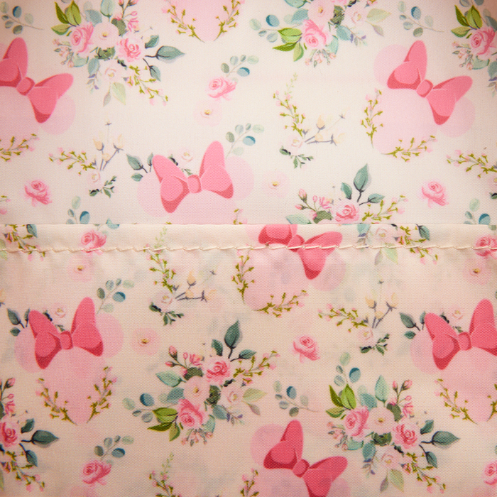 Close-up of the Loungefly Disney Minnie Mouse mini backpack showing the floral print with pink bows, roses and leafy sprigs.
