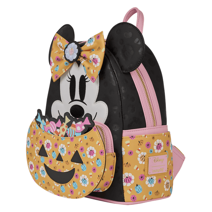 Angled front view of Loungefly Disney Minnie Mouse Halloween mini backpack with jack-o-lantern candy pocket, black body and pink trims