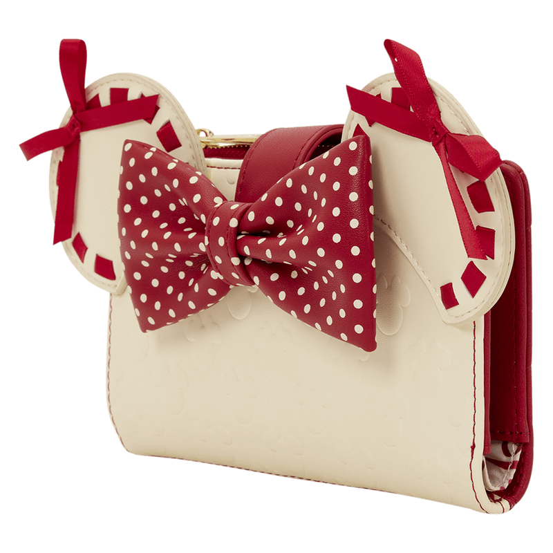 Angled view of the Loungefly Disney Minnie Rocks The Dots wallet showing Minnie ears, red polka dot bow and cream body with subtle embossed icons.