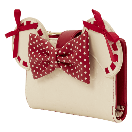 Angled view of the Loungefly Disney Minnie Rocks The Dots wallet showing Minnie ears, red polka dot bow and cream body with subtle embossed icons.