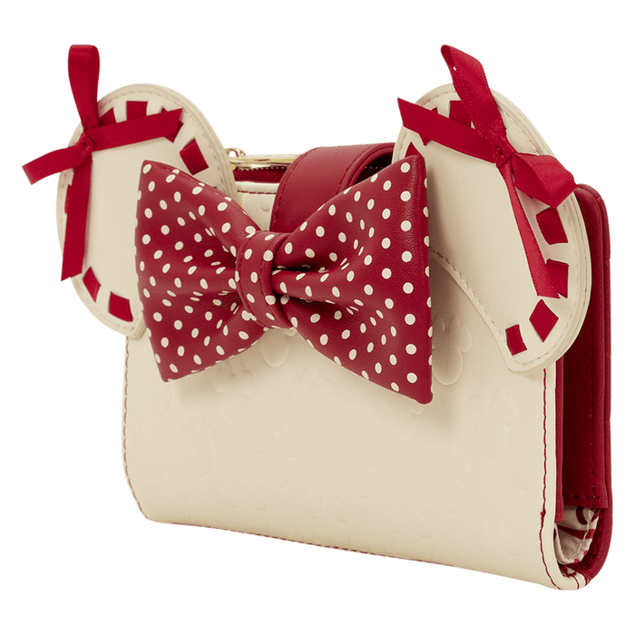 Angled view of the Loungefly Disney Minnie Rocks The Dots wallet showing Minnie ears, red polka dot bow and cream body with subtle embossed icons.
