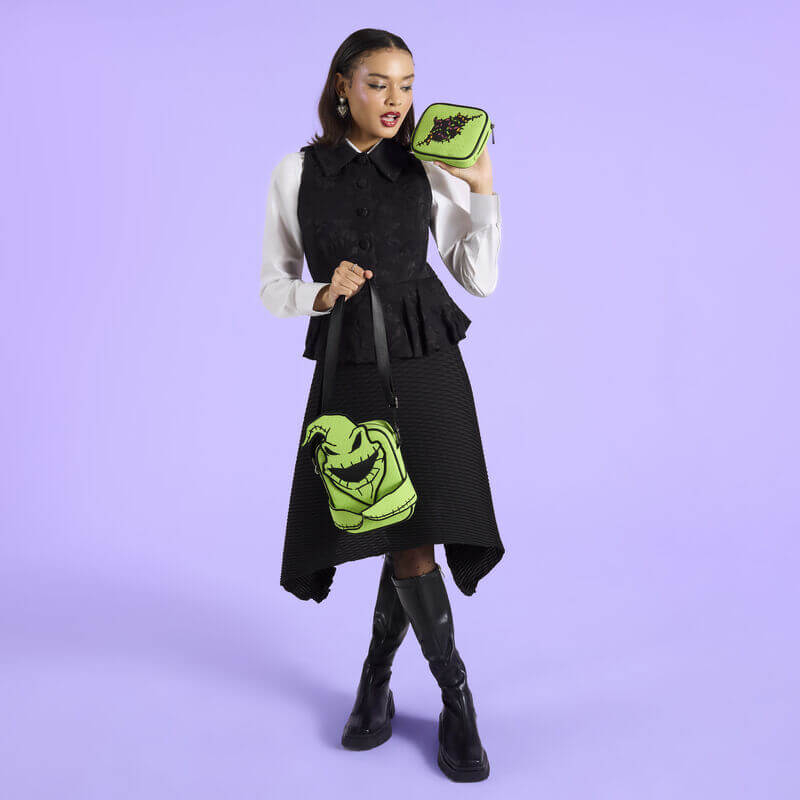 Model holding Loungefly Oogie Boogie Crossbuddy bag with green plush and removable pocket

