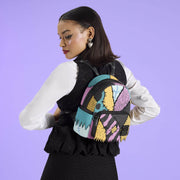 Model wearing Loungefly Disney Sally mini backpack against a purple background
