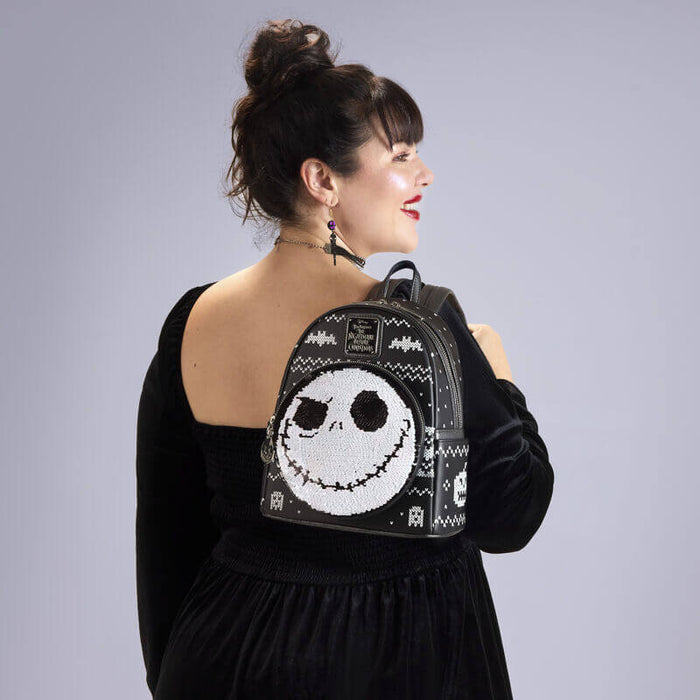 Model wearing Loungefly NBX sequin mini backpack with Jack Skellington face on front pocket.